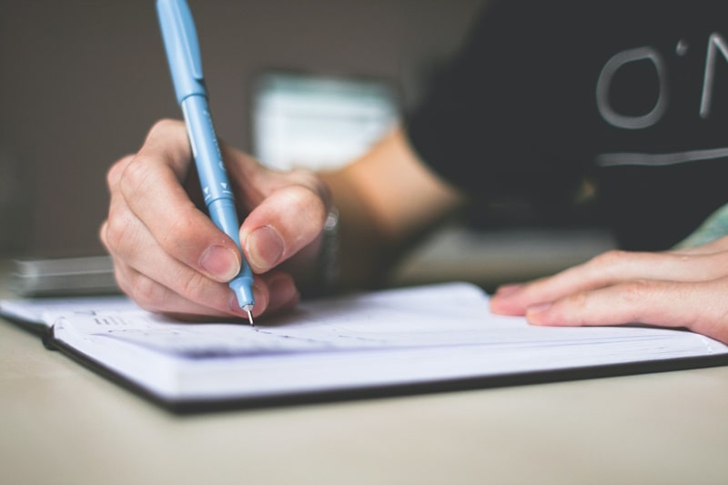 Person writing on a notebook
