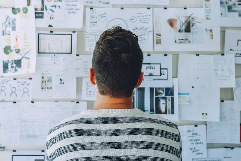 Person looking at a wall with different documents
