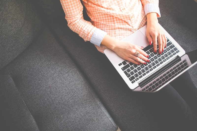 Person sitting on a couch working on a laptop