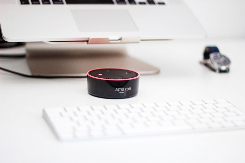 amazon, amazon loudspeaker on desk, apple keyboard. 